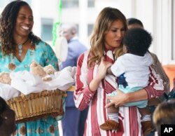 First lady Melania Trump holds a baby as she visits Greater Accra Regional Hospital in Accra, Ghana, Oct. 2, 2018.