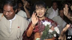 Myanmar opposition leader Aung San Suu Kyi, center, arrives at Rangoon International airport before departing for India in Rangoon, Burma Nov. 12, 2012.