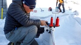 An employee of Titlis Bergbahnen sews together blankets for the coverage of parts of the glacier to protect it against melting on Mount Titlis near the Alpine resort of Engelberg, Switzerland July 2, 2021. (REUTERS/Arnd Wiegmann)