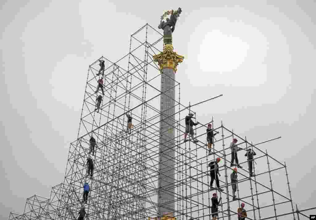 Para pekerja memasang konstruksi untuk perayaan Hari Kemerdekaan di Kyiv, Ukraina.
