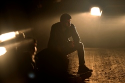 FILE - A detained migrant, who has crossed the Belarus-Latvia border, sits next to the border area near Vorzova, Latvia, August 11, 2021.