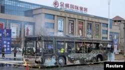 Firefighters are seen working inside a burnt bus after a fire on a street in Yinchuan, Ningxia Hui Autonomous Region, China, Jan. 5, 2016.