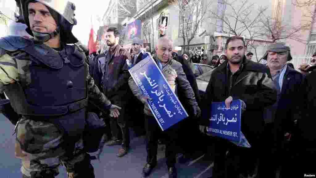 'Yan Sanda Kwantar Da Tarzoma Na Kasar Iran Na Kewaye Da Masu Zangazangar Kin Jinin Hukuncin Da Kasar Saudiyya Ta Yanke Ma Wani Mamin 'yan Shi'a, Janairu 4, 2016. 