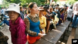Cambodian villagers line up to cast their vote in the country's national election at a polling station at Chak Angre Leu pagoda, in Phnom Penh, Cambodia, Sunday, July 28, 2013. 