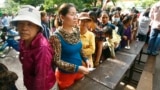 Cambodian villagers line up to cast their vote in the country's national election at a polling station at Chak Angre Leu pagoda, in Phnom Penh, Cambodia, Sunday, July 28, 2013. 
