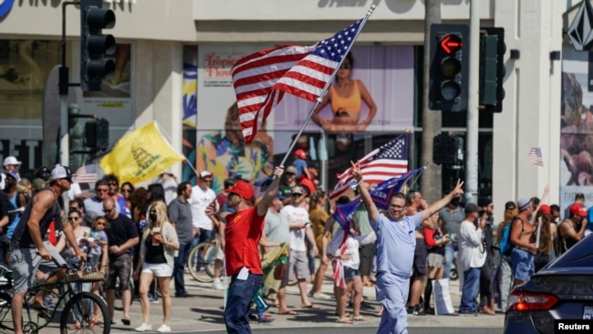 El técnico de rayos X, Kirk Lindeman se reúne con otros cerca del muelle de Huntington Beach para protestar contra la orden del gobernador Gavin Newsom de cerrar temporalmente las playas estatales y locales en el condado de Orange, durante el brote de la COVID-19. Primero de mayo de 2020.