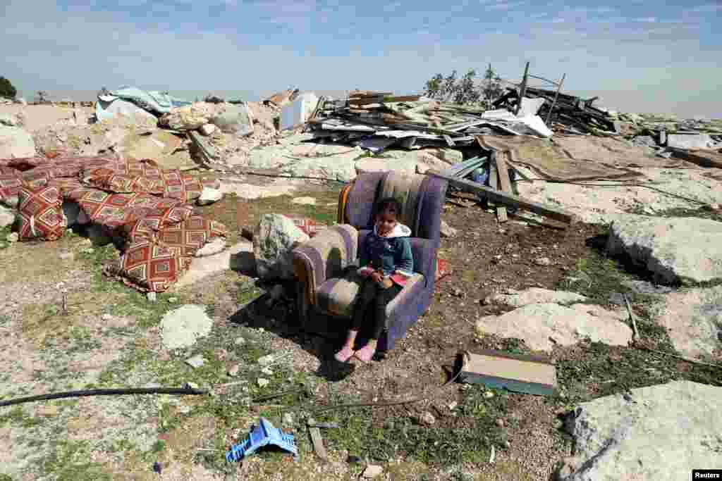 이스라엘 군이 예루살렘 동부 요르단 서안지구 알-에이자리야 지역을 철거한 후, 한 소녀가 부서진 소파에 앉아있다.