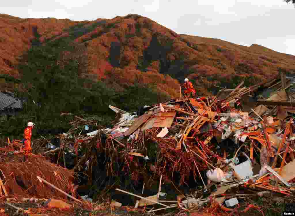 Firefighters search for missing people among collapsed houses following a landslide caused by Typhoon Wipha on Izu Oshima island, south of Tokyo, in this photo taken by Kyodo, Oct. 16, 2013.