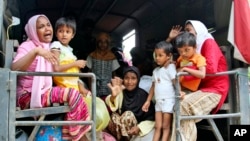 Ethnic Rohingya women and children whose boats were washed ashore on Sumatra Island board a military truck to be taken to a temporary shelter in Seunuddon, Aceh province, Indonesia, May 10, 2015. 