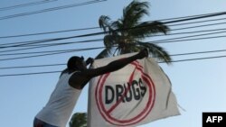 A former addict straightens a flag outside a sober house in Zanzibar
