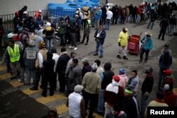 Migrants, part of a caravan of thousands traveling from Central America en route to the United States, line up for food in a makeshift camp in Mexico City, Mexico, Nov. 15, 2018.