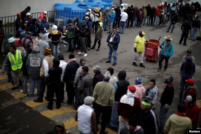 Migrants, part of a caravan of thousands traveling from Central America en route to the United States, line up for food in a makeshift camp in Mexico City, Mexico, Nov. 15, 2018.