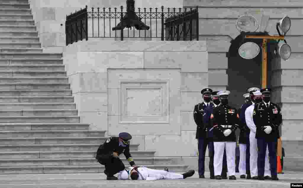 A member of a U.S. military honor guard is checked on after collapsing in the heat of the day as a hearse carrying the casket of civil rights pioneer and longtime U.S. Rep. John Lewis (D-GA) arrives at the U.S. Capitol in Washington.