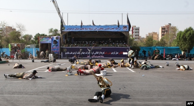 This picture taken on Sept. 22, 2018 in the southwestern Iranian city of Ahvaz shows injured soldiers lying on the ground at the scene of an attack on a military parade that was marking the anniversary of the outbreak of its devastating 1980-1988 war.
