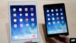 FILE - An Apple employee demonstrates the new iPad Air, left and iPad mini, Oct. 22, 2013, in San Francisco.