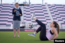 Laura Biondo, 32, from Venezuela, breaks the new Guinness World Record for "Most sit-down football crossovers in 30 seconds (female)" in Fort Lauderdale, Florida, U.S., in this undated handout photo. (Courtesy of Guinness World Records 2021/Juan Zabala)