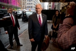 Vice President-elect Mike Pence, accompanied by his daughter Audrey, right, speaks to reporters as he arrives at Trump Tower in New York, Jan. 3, 2017.