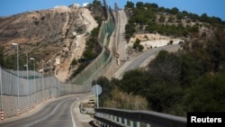 Border fence separating Morocco and Spain's north African enclave Melilla is seen along a road in the 12.5-square-kilometer territory, Dec. 4, 2013.