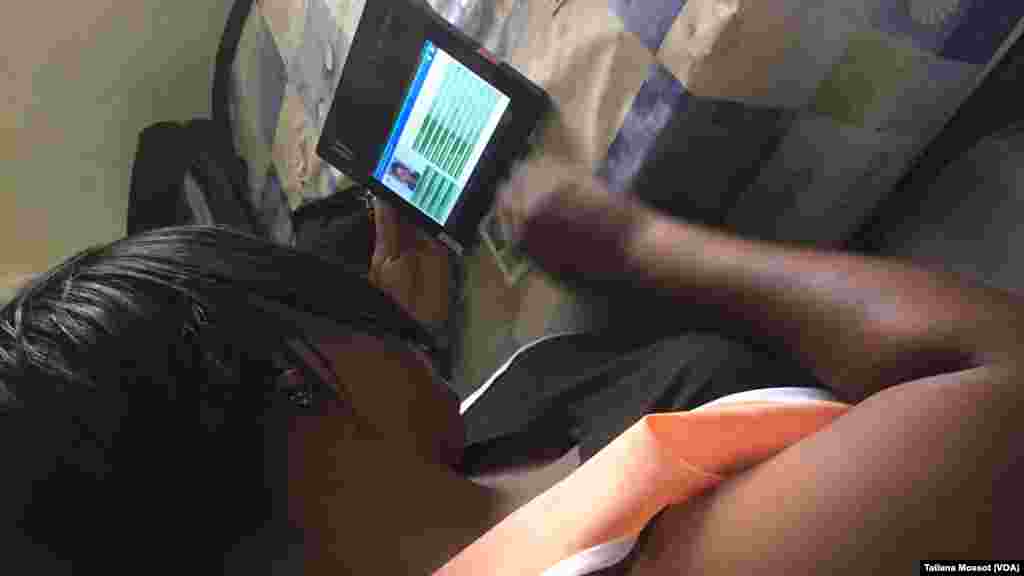 Une responsable de la CEI utilise une tablette électronique où figure chaque électeur.