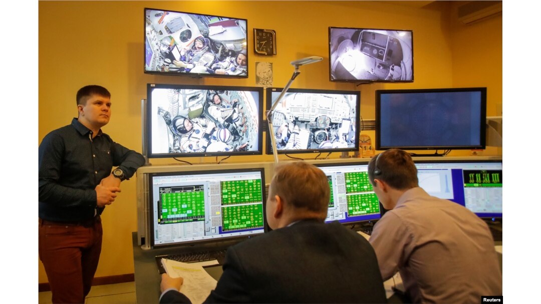 Specialists watch broadcasts from the Soyuz spacecraft showing astronaut David Saint-Jacques of Canada, Oleg Kononenko of Russia and astronaut Anne McClain of the U.S. attending the final qualification training for their upcoming space mission in Star City near Moscow, Russia, Nov. 14, 2018.