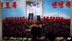မြောက်ကိုရီးယားခေါင်းဆောင် ကင်မ်ဂျုံအန်းနဲ့ ကွယ်လွန်သူ ခေါင်းဆောင်ဟောင်း ကင်ဂျုံအီးလ်တို့ဓာတ်ပုံအား မြောက်ကိုရီးယားနိုင်ငံ တည်ထောင်ခြင်းအထိမ်းအမှတ် အခမ်းအနားဓာတ်ပုံအဖြစ် တွေ့ရစဉ်။ 