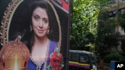 Indian policemen guard near a picture of Indian actress Sridevi displayed outside her residence in Mumbai, India, Feb. 27, 2018.