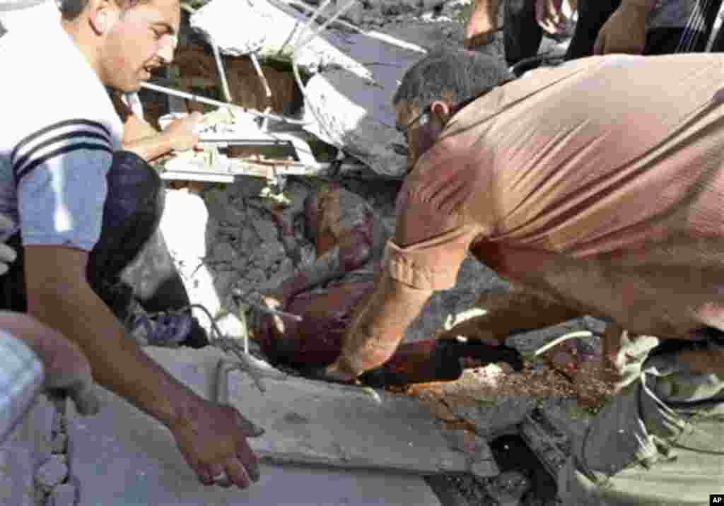 Warga Suriah mencoba mengevakuasi seorang pria yang cedera akibat terkubur di reruntuhan setelah serangan udara menghancurkan rumah-rumah di Azaz, pinggiran kota Aleppo (15/8).