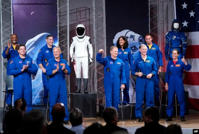 De izquierda a derecha los astronautas Victor Glover, Robert Behnken, Michael Hopkins, Douglas Hurley, Eric Boe, Sunita Williams, Christopher Ferguson, Josh Cassada y Nicole Mann son presentados en un evento de la NASA para anunciar que volarán al espacio en una cápsula SpaceX Dragon.