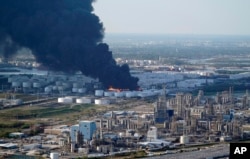 FILE - A plume of smoke rises from a petrochemical fire at the Intercontinental Terminals Company in Deer Park, Texas, March 18, 2019.