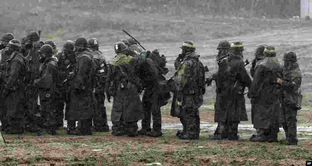 South Korean soldiers wearing gas masks gather during their military exercise in the border city of Paju, north of Seoul, South Korea, April 2, 2013.