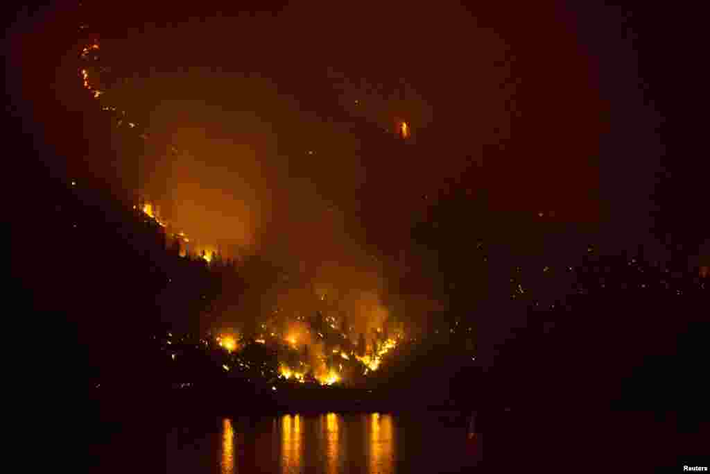 The Chelan Complex Fire in Chelan, Washington is reflected on Lake Chelan as pictured at night from Manson, Washington, Aug. 22, 2015.