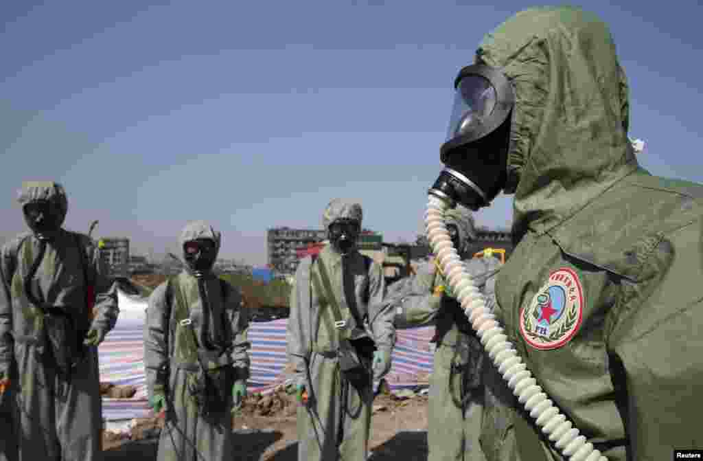 People's Liberation Army (PLA) soldiers of the anti-chemical warfare corps are seen in protection suits at the site of last week's blasts in Binhai new district of Tianjin, China. Four new fires have broken out at the site where two huge blasts last week killed 116 people.