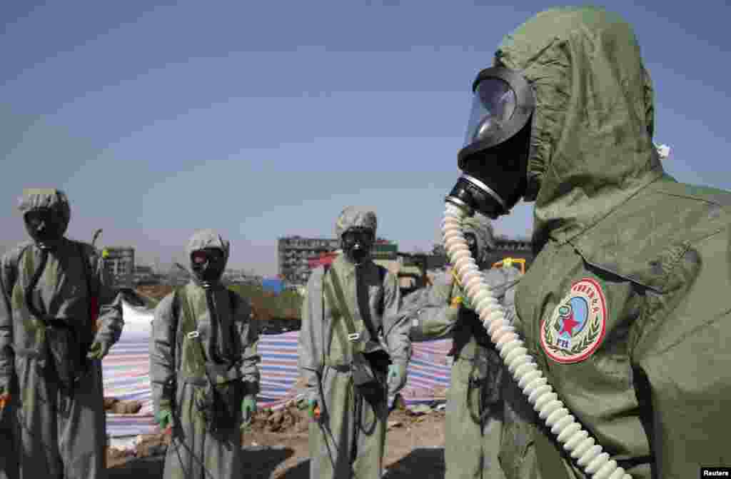 People&#39;s Liberation Army (PLA) soldiers of the anti-chemical warfare corps are seen in protection suits at the site of last week&#39;s blasts in Binhai new district of Tianjin, China. Four new fires have broken out at the site where two huge blasts last week killed 116 people.