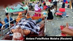 Survivors rest on beds outside a hospital in Palu, Sulawesi Island, Indonesia, Sept. 29, 2018, after the island was hit by an earthquake-triggered tsunami.