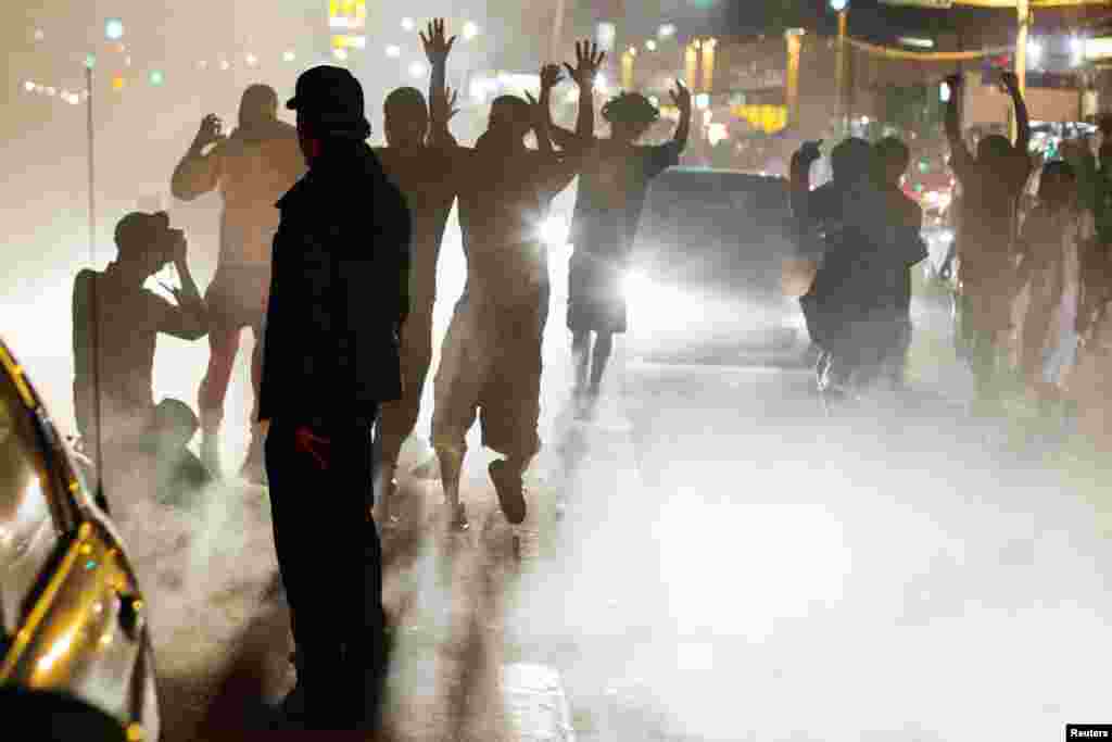 Demonstrators raise their hands as a symbol of protest of the shooting of Michael Brown, in Ferguson, Missouri, Aug. 15, 2014.