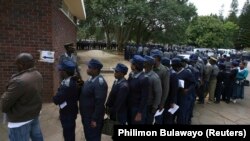 FILE: Zimbabwean police queue to vote in the capital Harare July 15, 2013. Zimbabwe's members of the uniformed forces are casting special votes in the general elections, which will take place across the country on July 31. REUTERS/Philimon Bulawayo (ZIMBABWE -