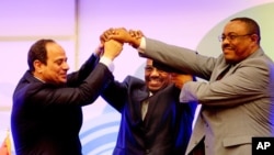 FILE - Sudanese President Omar al-Bashir, center, Egyptian President Abdel-Fattah el-Sissi, left, and Ethiopian Prime Minister Hailemariam Desalegn, right, hold hands after signing an agreement on sharing water from the Nile River, in Khartoum, Sudan, March 23, 2015.