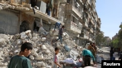 Stanovnici Alepa skupljaju svoje stvari iz ruševina zgrade posle vazdušnih napada u nedelju (REUTERS/Abdalrhman Ismail)