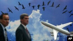 Dos hombres de negocios no identificados pasan por delante del stand ruso de Aviaexport PLC en el Berlin Air Show el miércoles 12 de mayo de 2004.