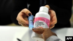 FILE - A mother gets an antiretroviral (ARV) drugs at the Chris Hani Baragwanath Hospital, South Africa's largest public hospital, in Soweto, May 16, 2012.