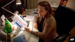 French journalist Ursula Gauthier, a reporter for the French news magazine L'Obs, holds a statement criticizing her from the Chinese Ministry of Foreign Affairs as she sits at her desk in her apartment in Beijing, Dec. 26, 2015.