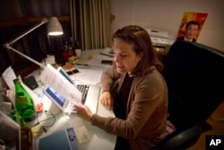 French journalist Ursula Gauthier, a reporter for the French news magazine L'Obs, holds a statement criticizing her from the Chinese Ministry of Foreign Affairs as she sits at her desk in her apartment in Beijing, Dec. 26, 2015.