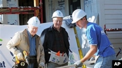Former President Jimmy Carter, left, former Vice-President Walter Mondale, center, and Minneapolis Mayor R.T. Rybak work together with volunteers with Habitat For Humanity to repair an old home in Minneapolis, Minn., 6 Oct 2010