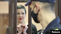 La opositora Maria Kolesnikova, esboza un corazón con sus manos, pese a estar esposada, durante su vista de sentencia, en Minsk, el 6 de septiembre de 2021.