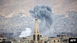 FILE - Smoke billows following a reported air strike in the rebel-held parts of the Jobar district, on the eastern outskirts of the Syrian capital Damascus.