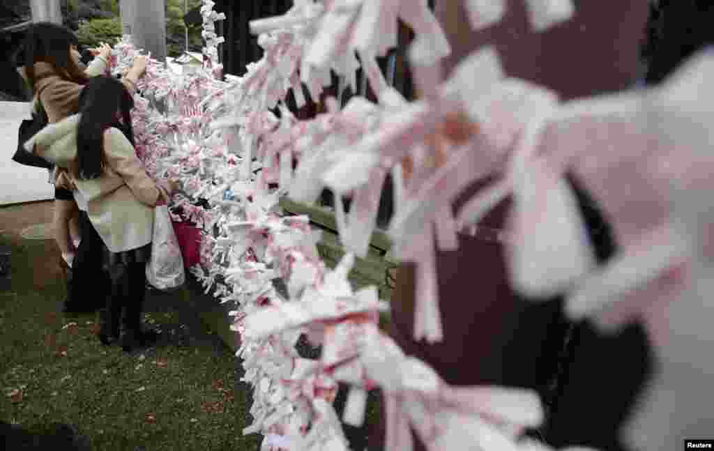 Visitors hang fortune blessing papers at Yasukuni Shrine in Tokyo, Dec. 26, 2013. 