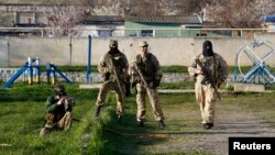 Armed men, believed to be Russian servicemen, stand guard at a military airbase in the Crimean town of Belbek near Sevastopol, Mar. 22, 2014.