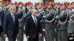 Austrian President Alexander Van Der Bellen, left, welcomes Russian President Vladimir Putin, right, with military honors for a meeting in Vienna, Austria, June 5, 2018. 