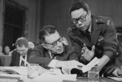 FILE - In this Feb. 8, 1985 photo, US Defense Secretary Casper Weinberger confers with Army Maj. Gen. Colin Powell during testimony before the Senate Budget Committee on Capitol Hill in Washington.
