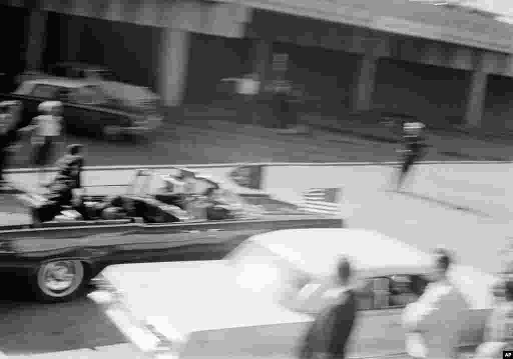 La limosina pasa a toda velocidad y cruza la Elm Street hacia la carretera Stemmons momentos después de que el presidente recibió el disparo en la plaza Dealey, en Dallas hace 50 años. 